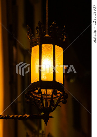 Vintage street lantern illuminated at night creating warm atmosphere Vintage street lantern illuminated at night creating warm atmosphere 125518937
