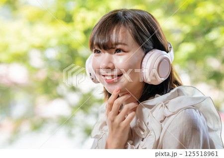 新緑が見える部屋で音楽を聴く若い女性 新緑が見える部屋で音楽を聴く若い女性 125518961