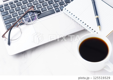 淹れたてのコーヒーを飲みながら、ノートパソコンでリモートワークをしているイメージ写真 125519329