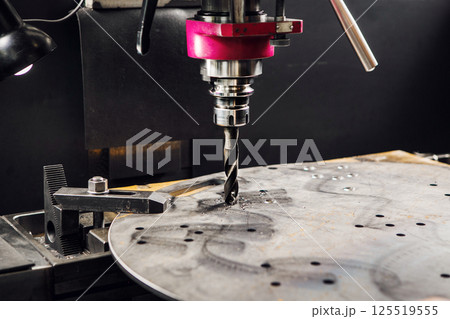 Vertical drill makes holes in metal part. Close-up of metal drilling machine. Vertical drill makes holes in metal part. Close-up of metal drilling machine. 125519555