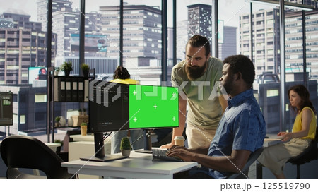 Developer using mockup PC, being assisted by colleague to fix applications issues, dealing with databases and server configuration. Team of IT workers using green screen computer, camera B Developer using mockup PC, being assisted by colleague to fix applications issues, dealing with databases and server configuration. Team of IT workers using green screen computer, camera B 125519790