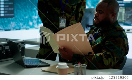 Angry army expert in a command post power base monitors satellite footage, yelling at soldier and throwing papers. Frustrated officer looks at real time data for operational success. Camera A. Angry army expert in a command post power base monitors satellite footage, yelling at soldier and throwing papers. Frustrated officer looks at real time data for operational success. Camera A. 125519803