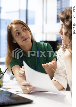 HR colleagues doing brainstorming, looking at CVs and doing background checks to potential job applicants. Teamworking employers reading resumes of candidates for vacant startup position 125519929