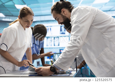 Radiologists and specialists examine x ray test results for the right treatment plans. Group of licensed healthcare experts working in a private clinic to provide medical services on insurance. 125520575