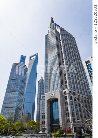 Shanghai, China - 1 April 2025: The iconic Jin Mao Tower and Shanghai Tower dominate the Pudong skyline under clear blue skies, showcasing Shanghai modern architectural prowess. 125520933