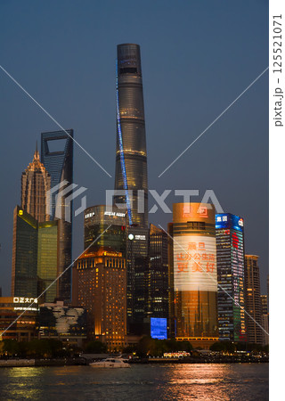 Shanghai, China - 1 April 2025: Evening skyline of Pudong district featuring illuminated Shanghai Tower, Shanghai World Financial Center, and Jin Mao Tower reflected in Huangpu River Shanghai, China - 1 April 2025: Evening skyline of Pudong district featuring illuminated Shanghai Tower, Shanghai World Financial Center, and Jin Mao Tower reflected in Huangpu River 125521071