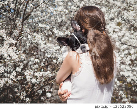 Cute woman holding puppy. Clear, sunny day 125522086