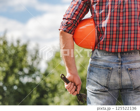 Attractive man in work clothes with a protective helmet Attractive man in work clothes with a protective helmet 125522136