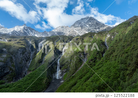 Aerial view of beautiful high altitude snow capped mountain waterfall landscape Aerial view of beautiful high altitude snow capped mountain waterfall landscape 125522188