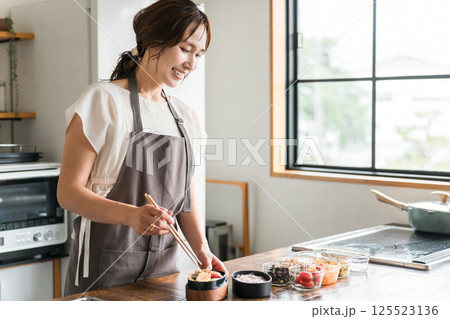 キッチンでお弁当を詰める若いアジア人女性（お母さん・妻・主婦） 125523136