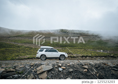 Driving off road car on the high altitude mountain top Driving off road car on the high altitude mountain top 125523203