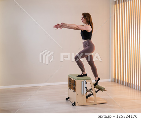Asian woman doing pilates classic chair.  125524170