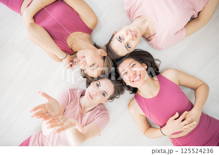 Top view of lying down Two Caucasian and two Asian women in sportswear.  125524236