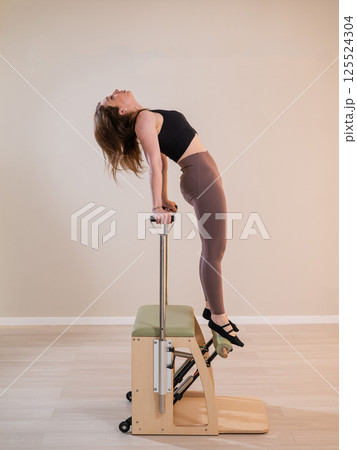 Asian woman doing pilates classic chair.  125524304