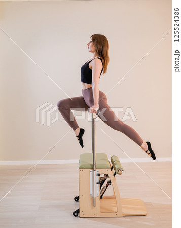 Asian woman doing pilates classic chair.  125524386
