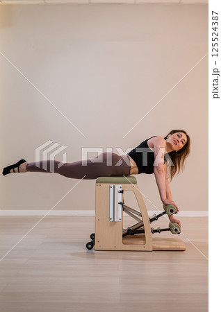 Asian woman doing pilates classic chair.  125524387