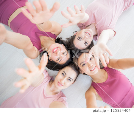 Top view of lying down Two Caucasian and two Asian women in sportswear.  125524404