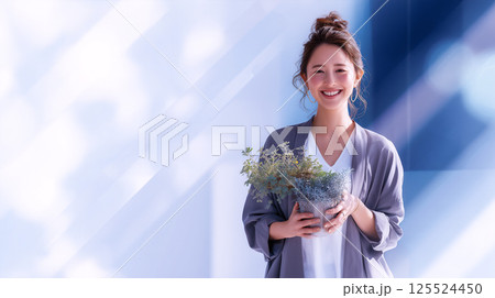 柔らかな光に包まれた植物を持つ笑顔の女性 125524450