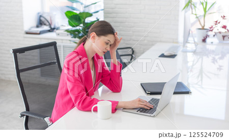 Caucasian woman makes mistake at work and holds her head.  125524709