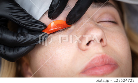 The master lays down the roller before the eyelash lamination procedure. The master lays down the roller before the eyelash lamination procedure. 125524725
