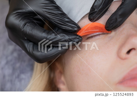 The master lays down the roller before the eyelash lamination procedure.  125524893