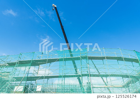 足場が組まれたビルの建設現場とクレーン（建築現場イメージ） 125526174