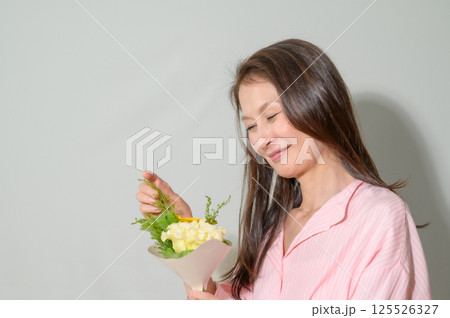 お花を手に持つシニア女性 125526327