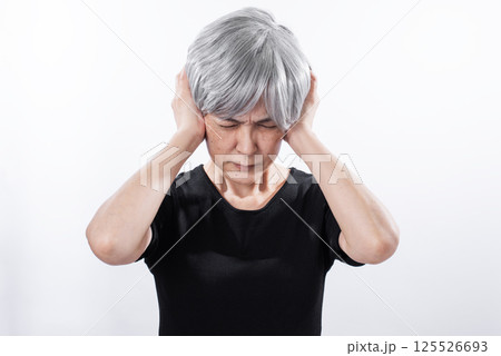 耳をふさぎ苦しそうなグレーヘアーのシニア女性 耳をふさぎ苦しそうなグレーヘアーのシニア女性 125526693