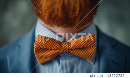 Orange bow tie on blue suit. 125527224