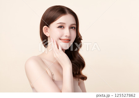 A beautiful young Asian woman with clean, fresh skin against a beige background. Skincare, facial treatment, cosmetology, beauty, and spa. An elegant portrait of an Asian woman. A beautiful young Asian woman with clean, fresh skin against a beige background. Skincare, facial treatment, cosmetology, beauty, and spa. An elegant portrait of an Asian woman. 125527862