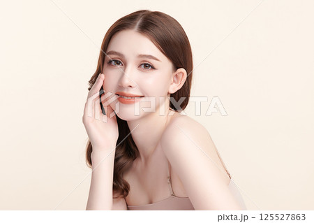 A beautiful young Asian woman with clean, fresh skin against a beige background. Skincare, facial treatment, cosmetology, beauty, and spa. An elegant portrait of an Asian woman. A beautiful young Asian woman with clean, fresh skin against a beige background. Skincare, facial treatment, cosmetology, beauty, and spa. An elegant portrait of an Asian woman. 125527863