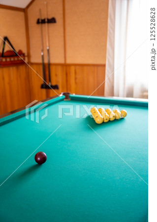 Initial billiard ball arrangement with white balls in a triangle and red cue ball ready for the break. Concept of indoor recreation and personal hobby space 125528628
