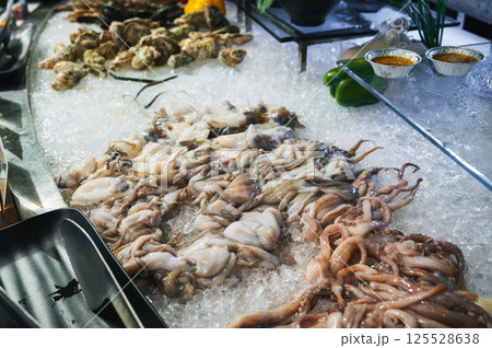 seafood in the Asian buffet at the hotel in restaurant in Asia. Chilled fresh octopus and squid on ice at night market in Vietnam seafood in the Asian buffet at the hotel in restaurant in Asia. Chilled fresh octopus and squid on ice at night market in Vietnam 125528638