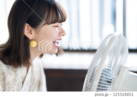 扇風機で涼む浴衣を着た若い女性 扇風機で涼む浴衣を着た若い女性 125528851