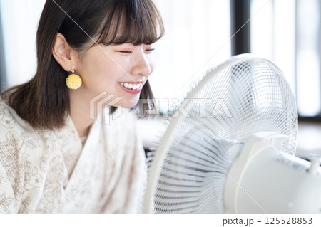 扇風機で涼む浴衣を着た若い女性 125528853