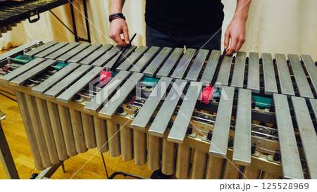 A young guy playing the vibraphone at a music school. 125528969