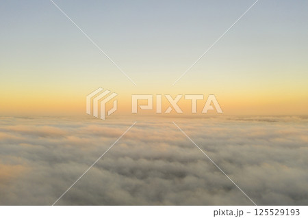 Aerial view gold sunrise over clouds in blue sky. Aerial top view cloudscape. Texture of clouds. View from above. Orange sunrise or sunset over clouds. Panorama clouds texture Aerial view gold sunrise over clouds in blue sky. Aerial top view cloudscape. Texture of clouds. View from above. Orange sunrise or sunset over clouds. Panorama clouds texture 125529193