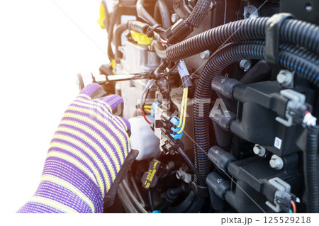 Repairing outboard marine engine. Motorboat engine seasonal service and maintenance. Mechanic yfnd performing maintenance on outboard engine Repairing outboard marine engine. Motorboat engine seasonal service and maintenance. Mechanic yfnd performing maintenance on outboard engine 125529218