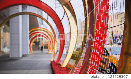 Christmas decorations creating a tunnel of lights in a city street Christmas decorations creating a tunnel of lights in a city street 125529307