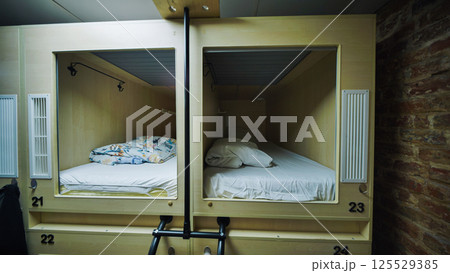 Capsule hotel beds providing comfortable and private sleeping spaces 125529385