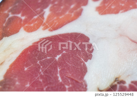 Top view of smoked pork salami chorizo sausages slices background. Raw smoked salami pattern 125529448