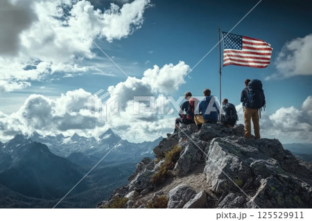A group of people are sitting on a mountain top with a flag in the background 125529911