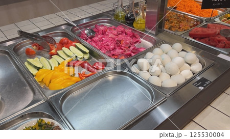 Self-service buffet offering fresh and colorful vegetables, eggs, and watermelon Self-service buffet offering fresh and colorful vegetables, eggs, and watermelon 125530004