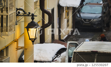 Vintage street lamp illuminating snowy alley in winter 125530207