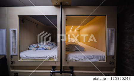 Capsule hotel beds providing comfortable and private sleeping spaces Capsule hotel beds providing comfortable and private sleeping spaces 125530248