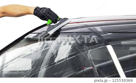 A man cleaning car with plastic sponge. Car detailing or valeting concept. Selective focus. Car detailing. Cleaning with sponge and cloth. Worker cleaning. Car wash concept solution to clean 125530369