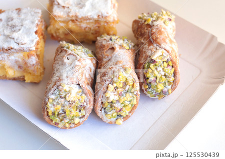 Cannoli traditional dessert of Italy. Food and sweets. Tubes of dough with filling. National cuisine. Cannoli traditional dessert of Italy. Food and sweets. Tubes of dough with filling. National cuisine. 125530439