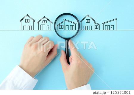 住宅や物件を虫眼鏡で探す人物の手元 住宅や物件を虫眼鏡で探す人物の手元 125531001