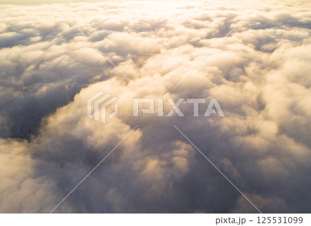 Aerial view White clouds in blue sky. Top view. View from drone. Aerial bird's eye view. Aerial top view cloudscape. Texture of clouds. View from above. Sunrise or sunset over clouds 125531099