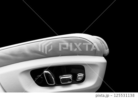 White leather interior of the luxury modern car. Perforated white leather comfortable seats with stitching isolated on black background. Modern car interior details. Car detailing. Car inside White leather interior of the luxury modern car. Perforated white leather comfortable seats with stitching isolated on black background. Modern car interior details. Car detailing. Car inside 125531138